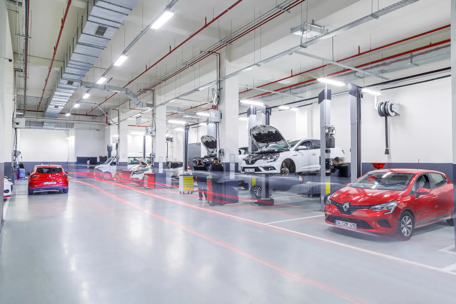 Long, clean service hall with cars in the bays