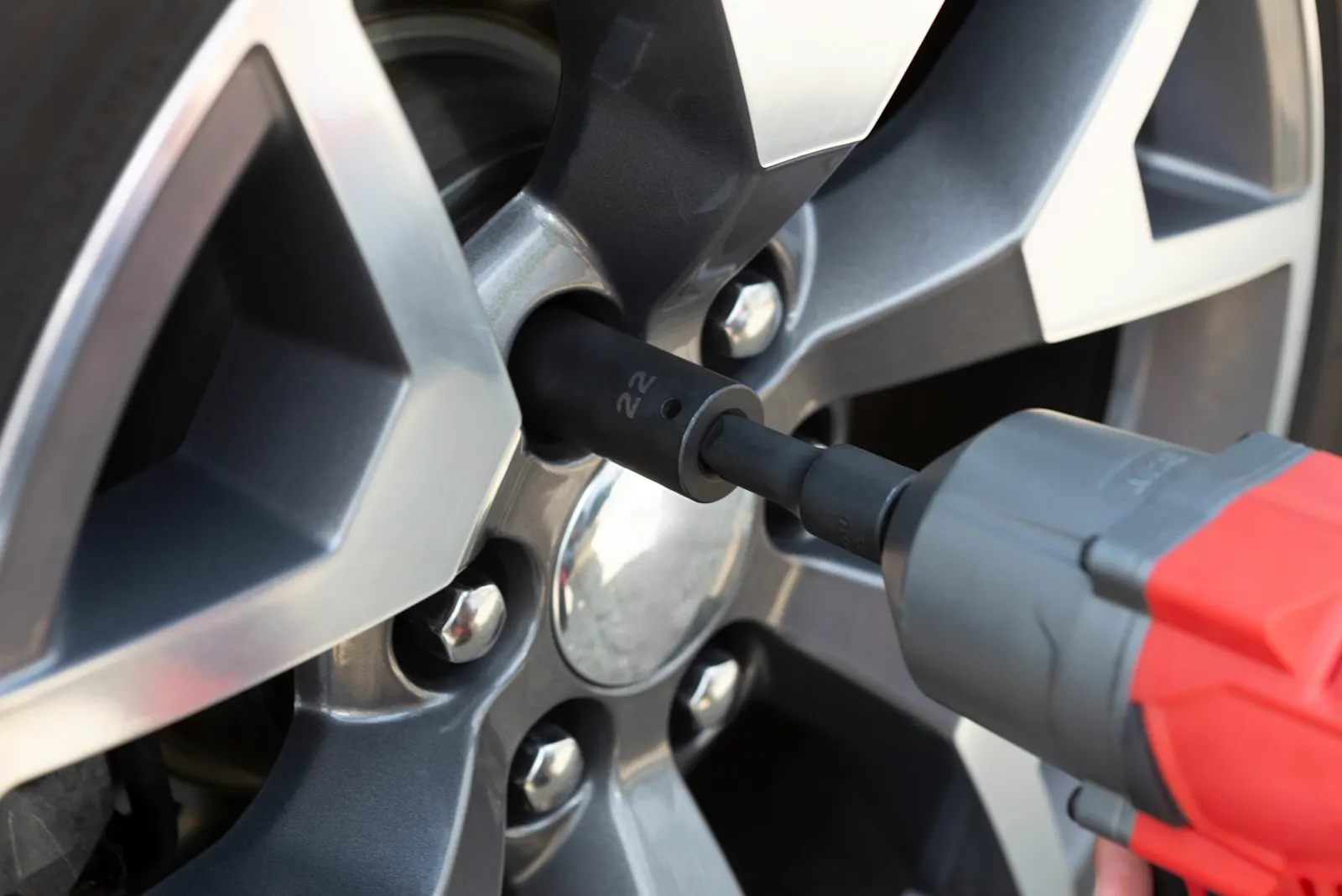Impact wrench removing a lug nut from an alloy wheel