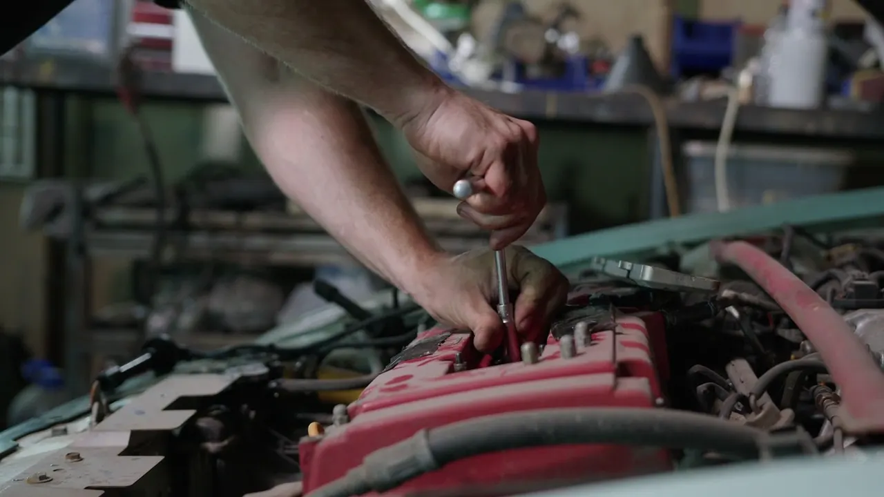 Hands turning a wrench on an engine
