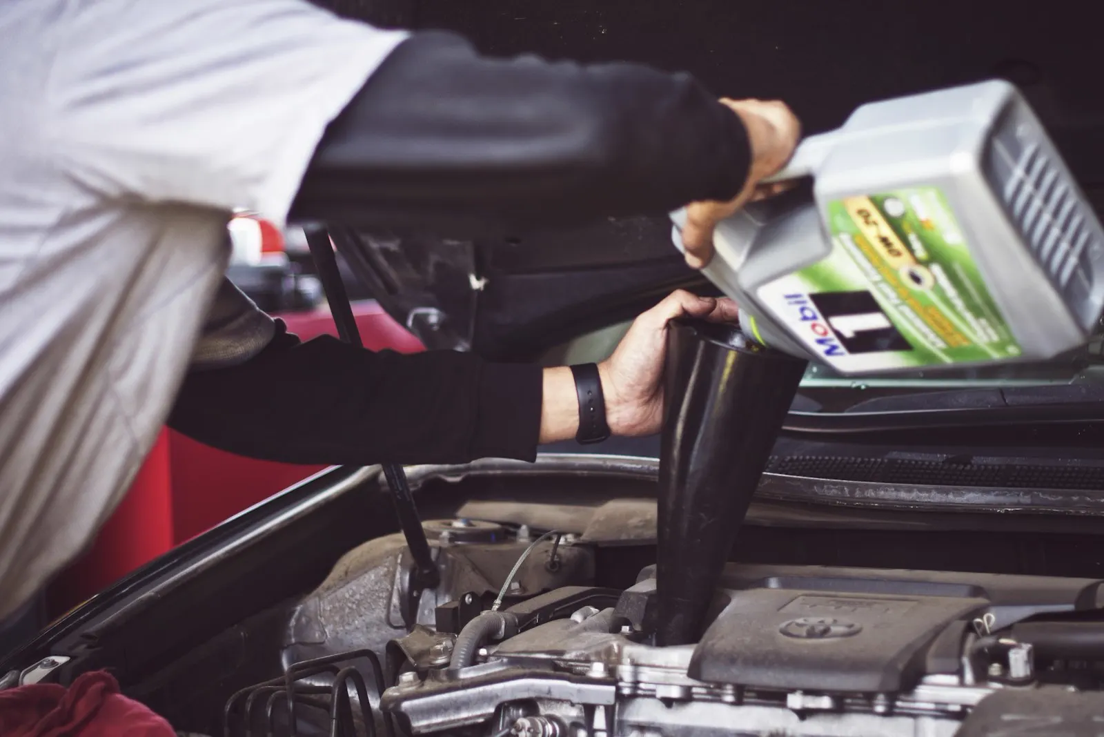 Mechanic pouring fresh oil into an engine