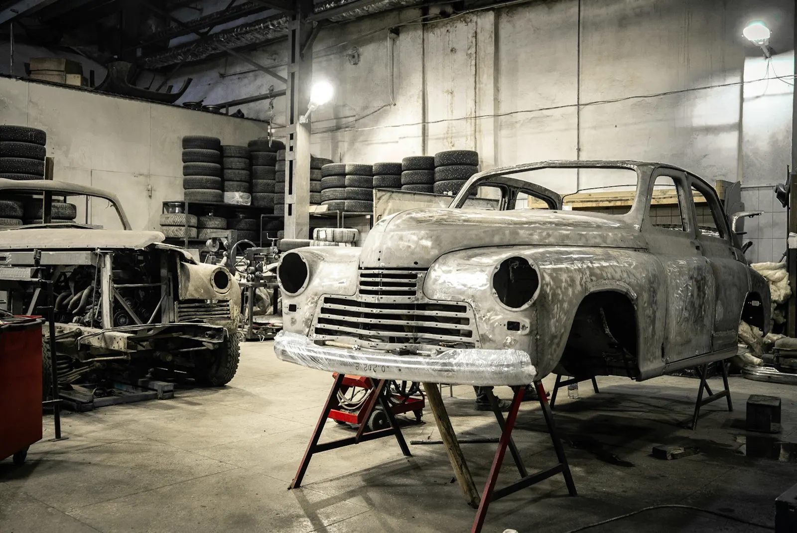 A vintage car body on stands in the workshop